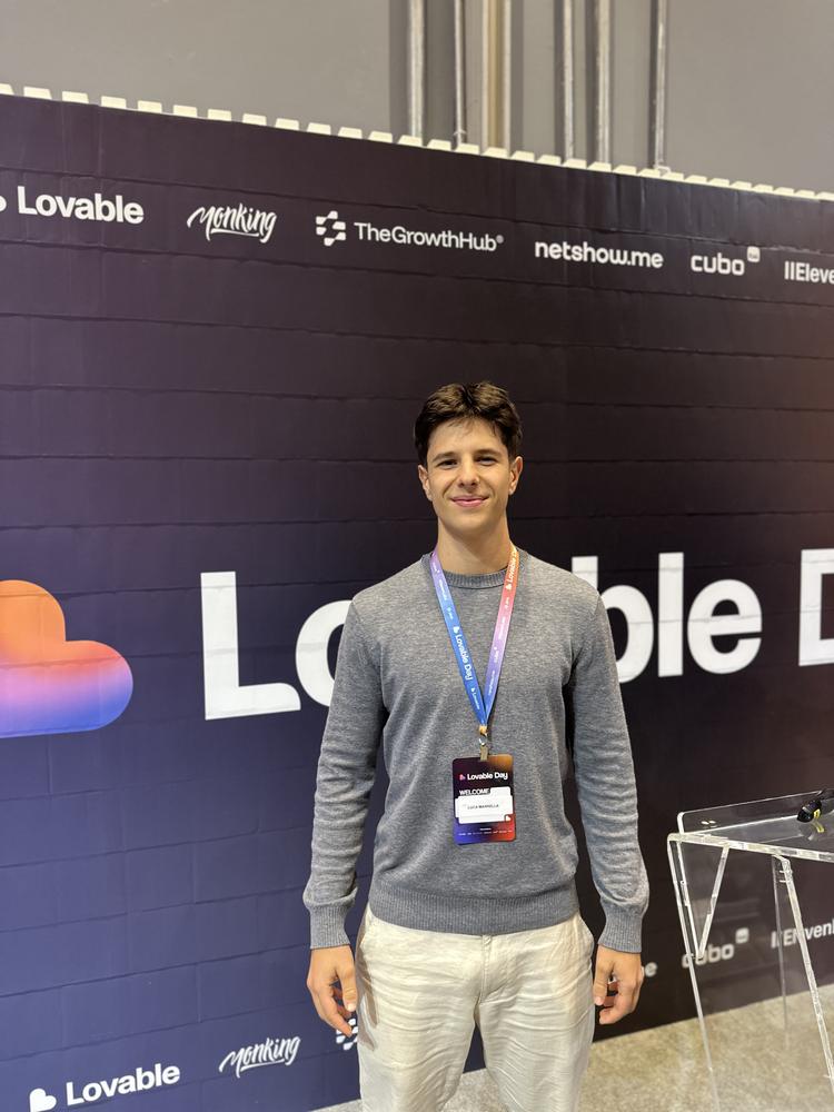 Luca wearing a Lovable Day badge in front of the event backdrop